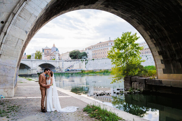 Newly-weds walking on Castel Sant'Angelo bridge during their Sposi Novelli Photo shoot