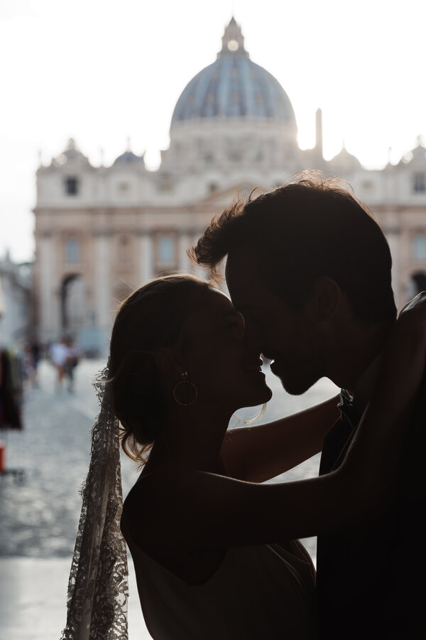 Beautiful couple in silhouette kissing during their Sposi Novelli Photo shoot in Via della Conciliazione