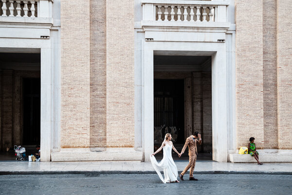 Newly-wed couple walking down Via della Conciliazione during their Sposi Novelli Photo shoot in Rome