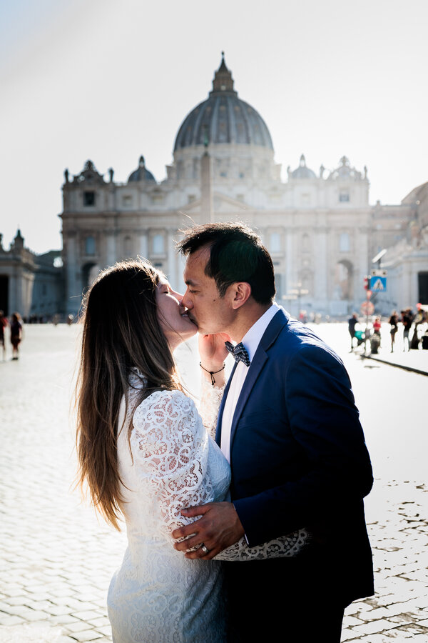 Happy newly-weds kissing with the Vatican in the background during their Sposi Novelli photo shoot