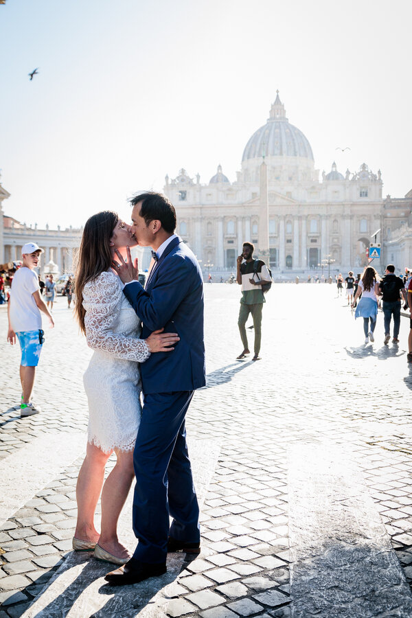 Newly-weds in Via della Conciliazione kissing with the Vatican in the background during their Sposi Novelli photo shoot