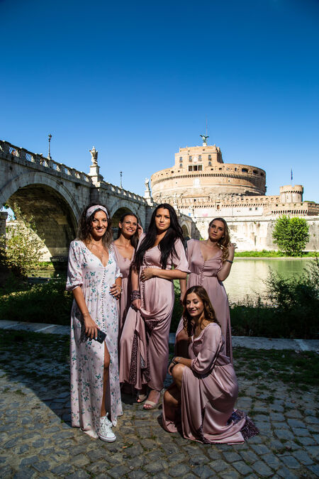 A full-length portrait of bride and bridesmaids on the Tiber riverbank with the iconic Castel Sant'Angelo in the background