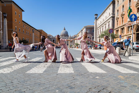 Bachelorette portrait of bride and bridesmaids having fun on zebra crossing in Via della Concilizazione, Vatican, Rome