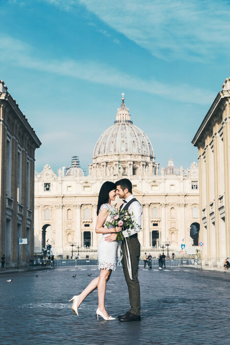 Newly-wed couple in a deserted Via della Conciliazione, with the Saint Peter's in the background