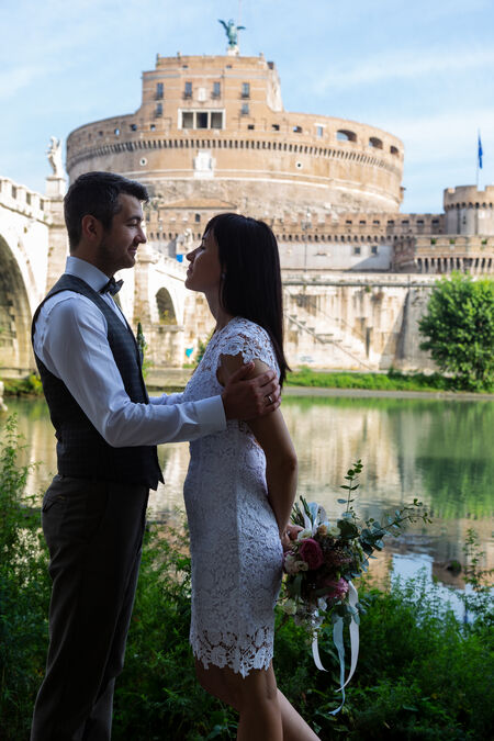 Young wedding couple in a tender moment on the Tiber's bank during their wedding photo session