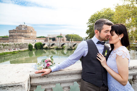 Newly-Wed couple In each other's arms, on Umberto I Bridge, with Castel Sant'Angelo in the background