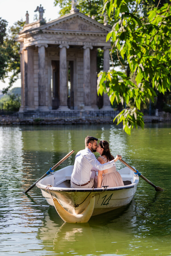 Kissing couple on a rowboat with the Temple of Esculapio in the background.