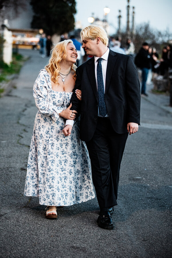 Beautiful newly-engaged couple walking hand in hand at the Pincio Gardens in Rome