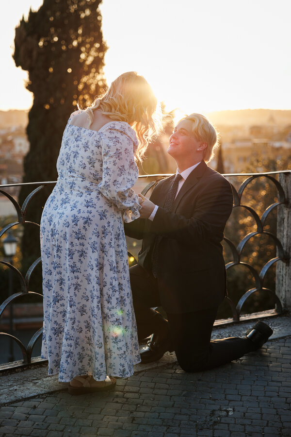 Beautiful couple during their wedding proposal at the Pincio Gardens in Rome in the warm light of sunset