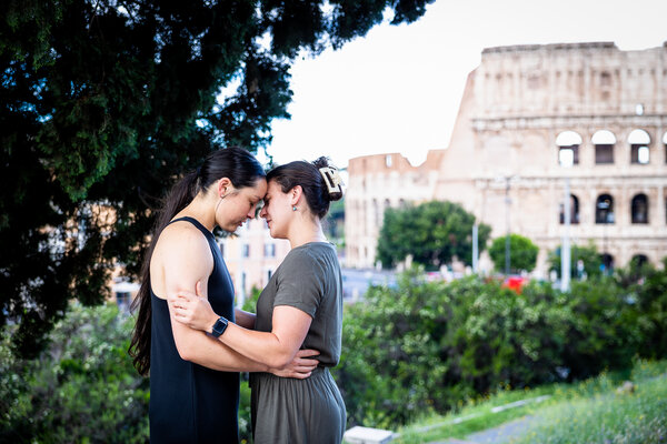 Beautiful female same-sex couple holding each other head to head on Mounte Oppio near the Colosseum