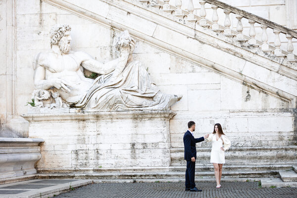 Newly-engaged couple new the River Nile God statue on the Capitoline Hill during their engagement photo session in Rome