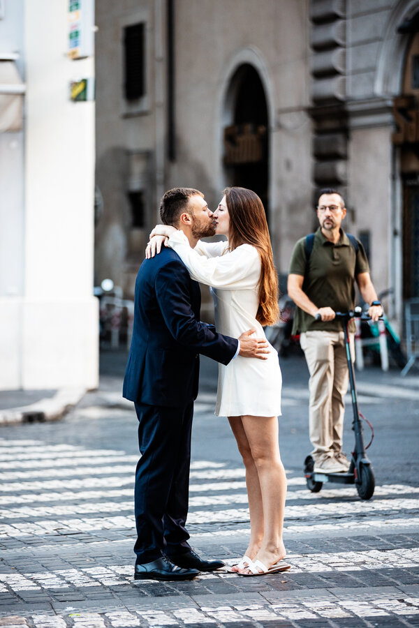 Newly-engaged couple kissing on the zebra crossing during their engagement photo session in Rome