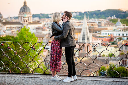 Newly-engaged couple kissing during their proposal photo session at the Pincio Gardens in Rome