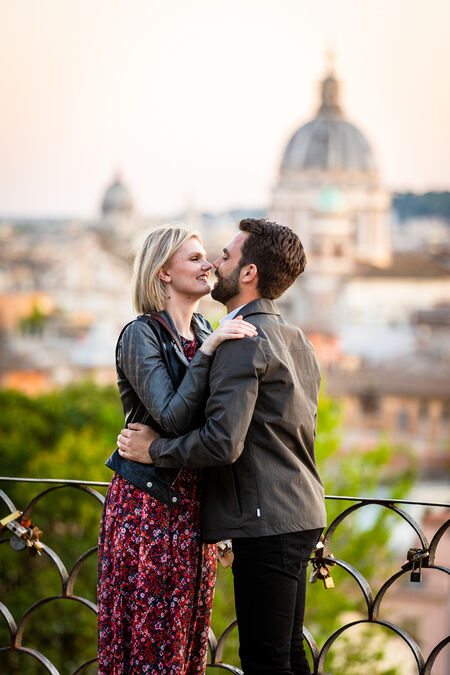 Newly-engaged couple smiling at each other on the Terrazza Belvedere in Rome