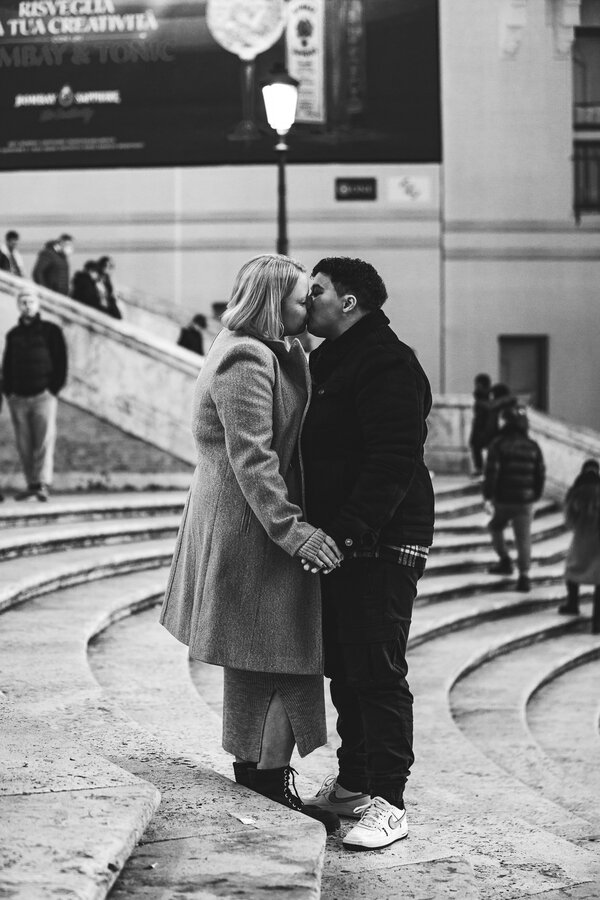 Couple kissing on the Spanish Steps during their proposal photo session in Rome
