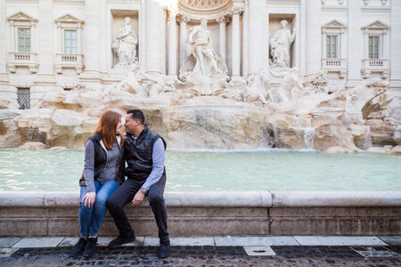 Couple sitting on the rim of the Trevi Fountain
