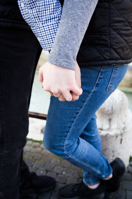 A newly-engagement couple holding hands with a closeup of a beautiful ring