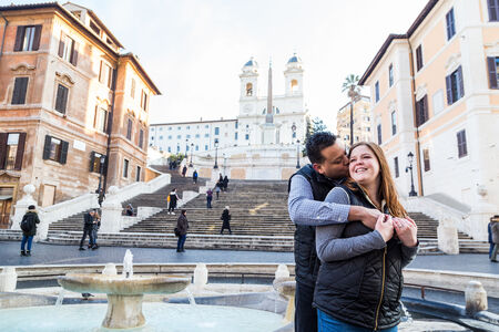 A sweet kiss between newly-engaged couple with the Spanish Steps in the background