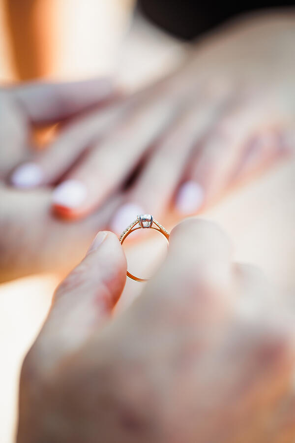 Close-up of a beautiful engagement ring being on the fiancée's hand