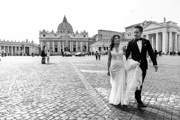 Newly-wed couple walking down Via della Conciliazione during a Sposi Novelli photo shoot in Rome