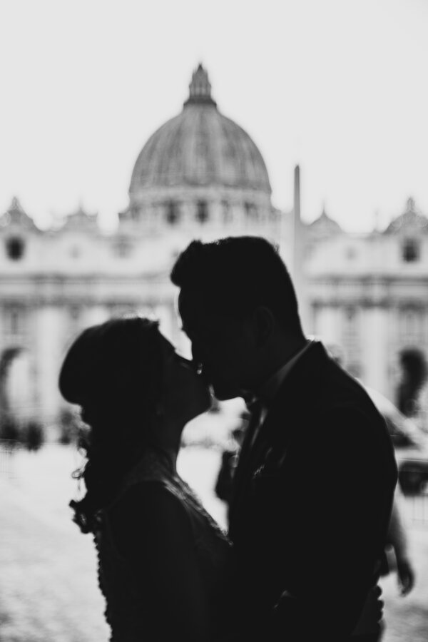 Silhouette of Sposi Novelli couple kissing with St Peter's in the background