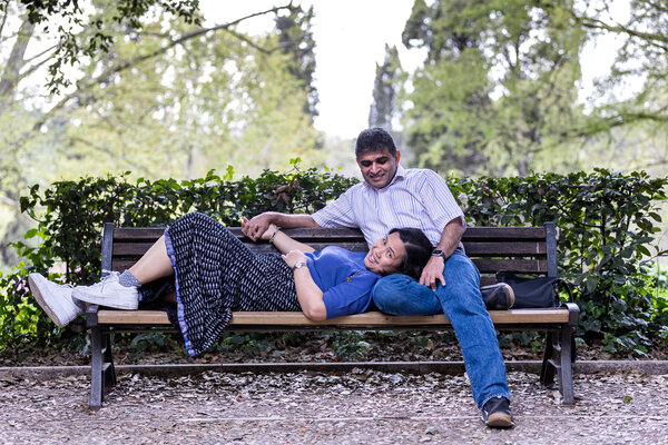 A happy couple relaxing on a bench in Villa Borghese in Rome