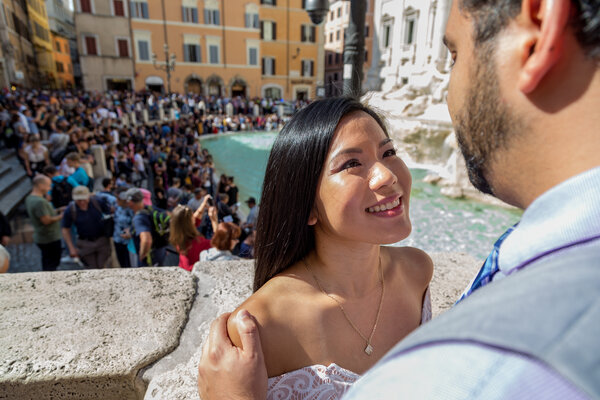 Couple smiles at each other with the Trevi Fountain in the background