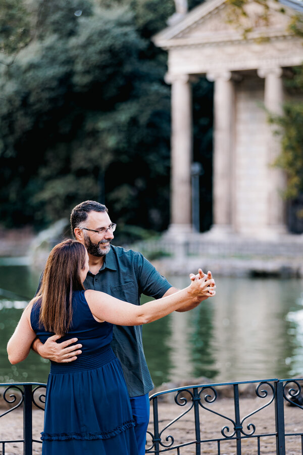 Couple dancing and celebrating their 15th wedding anniversary by the pond in Villa Borghese in Rome