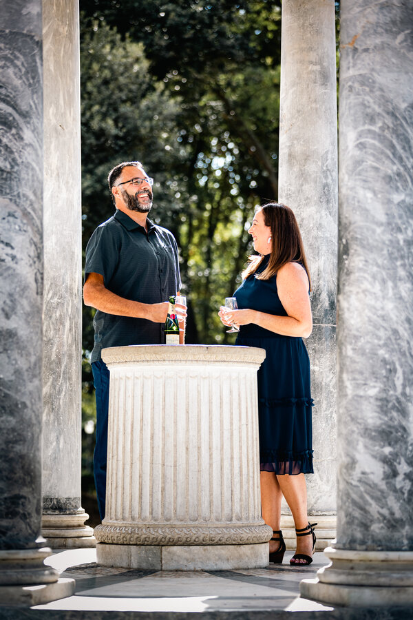 Couple smiling and enjoying champagne under the Temple of Diana in Villa Borghese in Rome