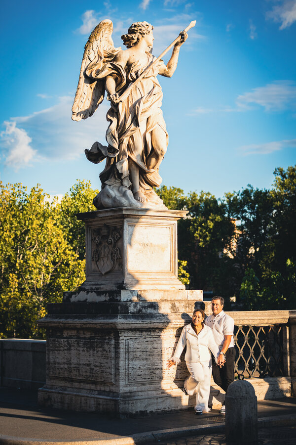 Couple on Castel Sant'Angelo Bridge on their anniversary photo shoot in Rome