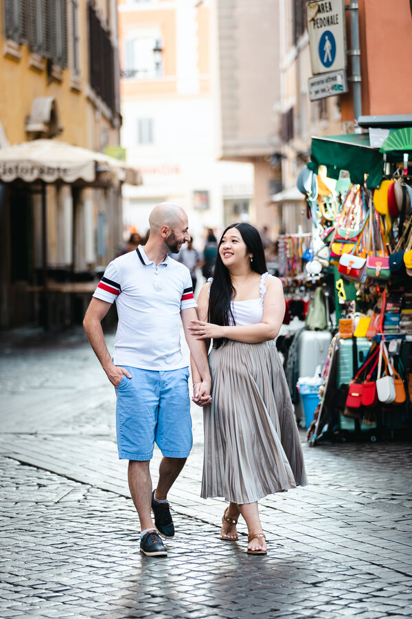 Happy newly-engaged couple walking celebrating their engagement in Rome with an early photo shoot at the Trevi Fountain