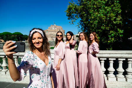 Bride taking a selfie of her and her bridesmaids with Castel Sant'Angelo in the background