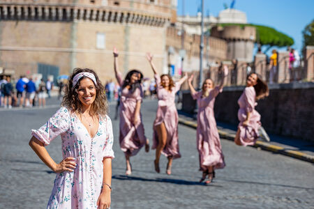 Bachelorette Photo Session in Rome with bride in the foreground and bridesmaids in the background jumping, at Castel Sant'Angelo
