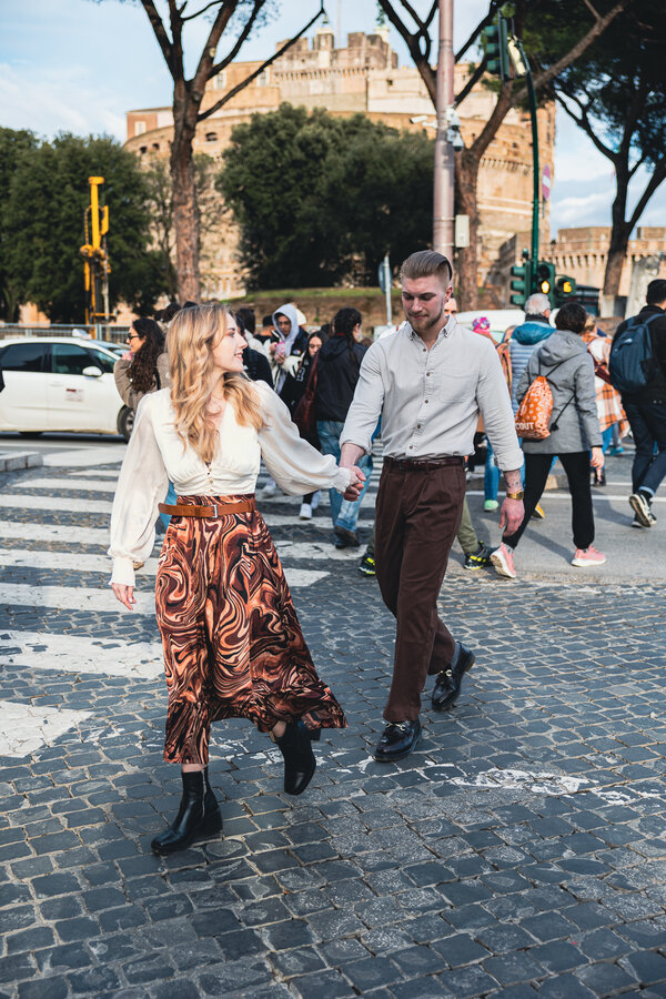 Newly-engaged couple stolling near Castel Sant'Angelo during their engagement photo session in Rome