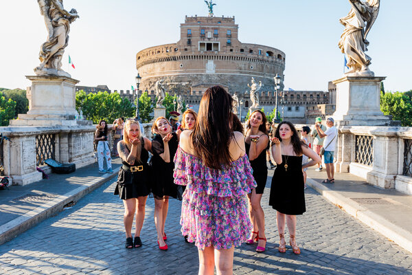 Bachelorette girls air kissing the bride to-be on Castel Sant'Angelo Bridge in Rome 