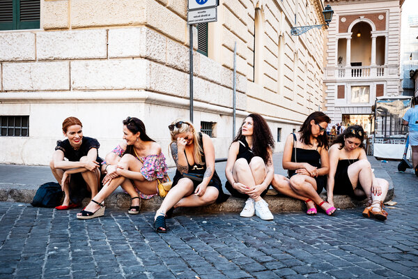 Bachelorette bridesmaids resting on the sidewalk in Rome