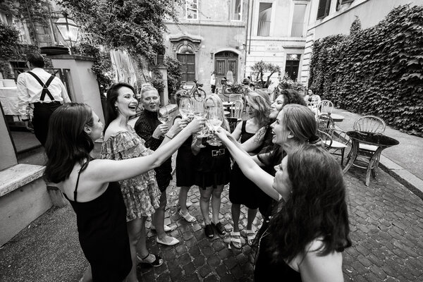 Black & white image of bridesmaids toasting in circle