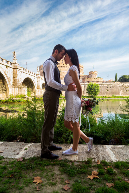 A romantic portrait of a young wedding couple with a beautiful panorama of Castel Sant'Angelo and Ponte Sant'Angelo in Rome