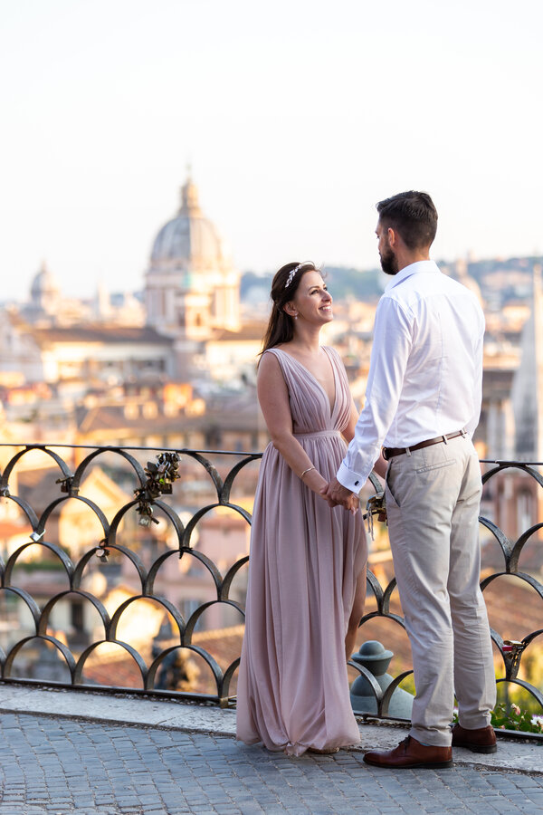 Newly-wed couple, holding hands at the Belvedere of the Pincio Gardens, overlooking the Eternal City.