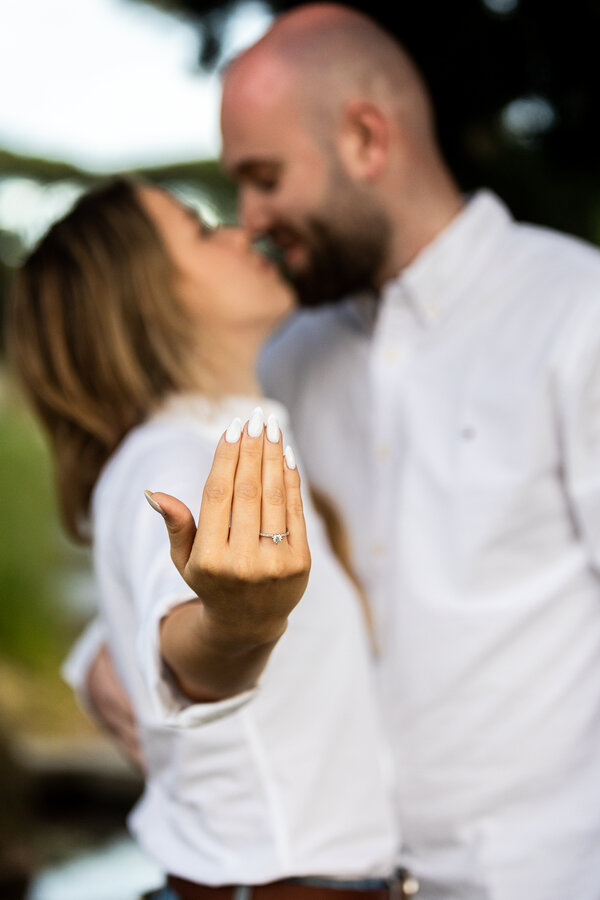 Newly-engaged couple showing her new engagement ring during their surprise proposal photo shoot in Rome