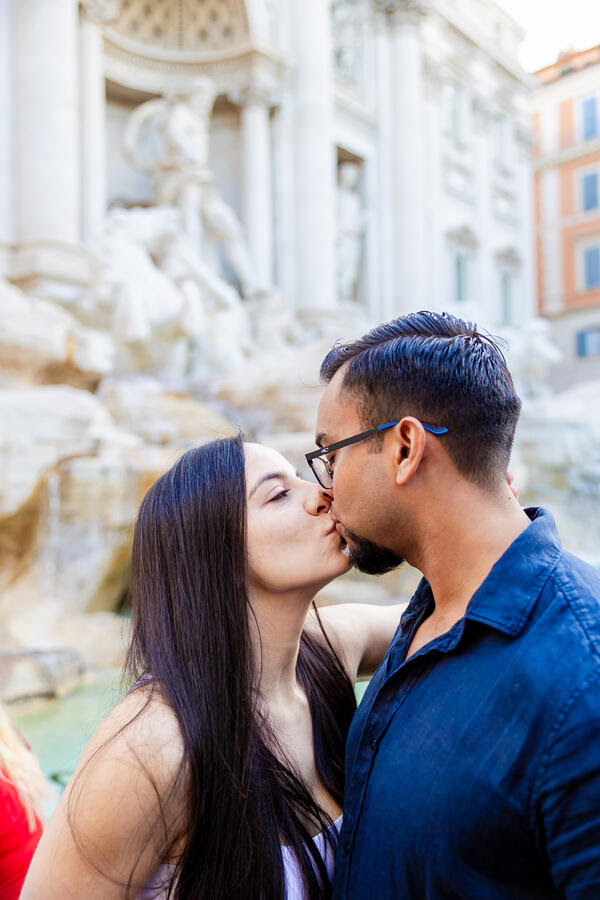 Newly-engaged couple kissing at the Trevi Fountain in Rome