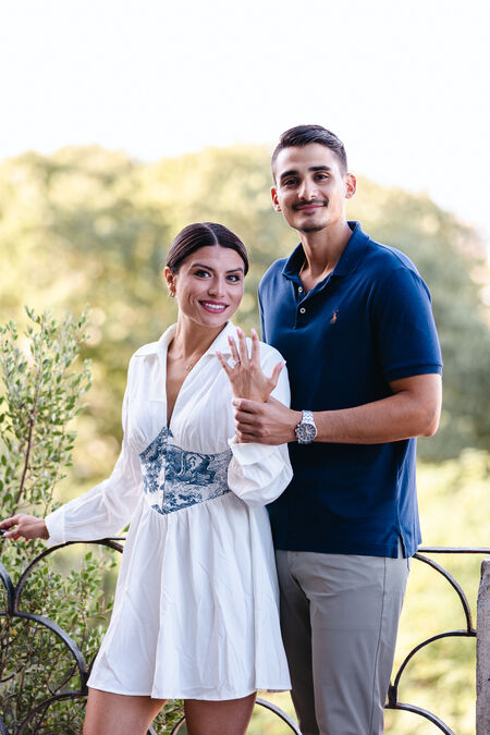 Newly-engaged couple on the Terrazza Belvedere in Rome showing off the engagement ring during their surprise marriage proposal photo shoot