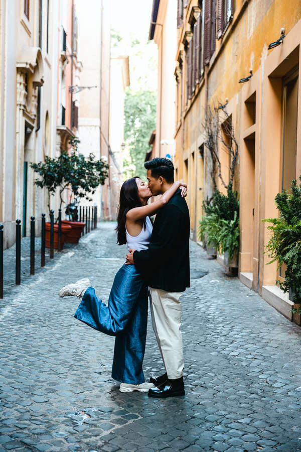 Happy newly-engaged couple in Rome kissing each other