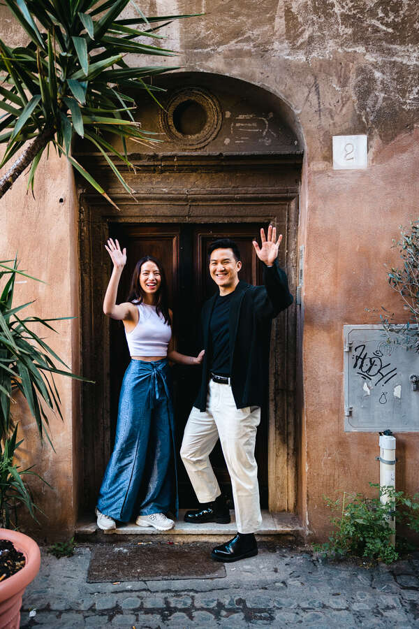 Happy newly-engaged couple waving goodbye during their engagement photoshoot in Rome