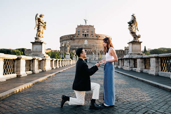 Couple proposing in Rome on Castel Sant'Angelo Bridge early in the morning