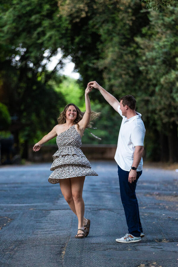 Newly-engaged couple dancing during their surprise proposal photo shoot at the Pincio Gardens in Rome
