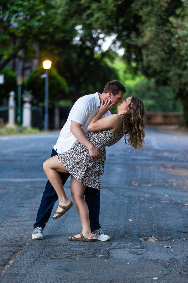 Newly-engaged couple doing the dip on their surprise proposal photo shoot at the Pincio Gardens in Rome
