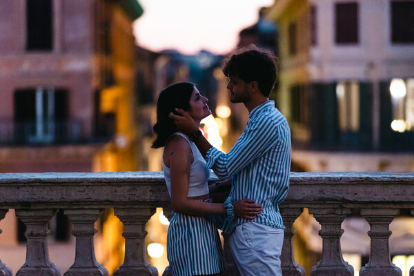Newly-engaged couple looking into each other's eyes on the Spanish Steps at sunset in Rome