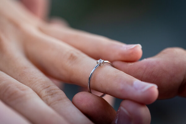 Close-up of the engagement ring on the fiancé's finger taken during a surprise proposal photo session in Rome