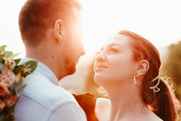 Couple romantically looking at each backlit by the sunset sun at the Pincio Gardens in Rome